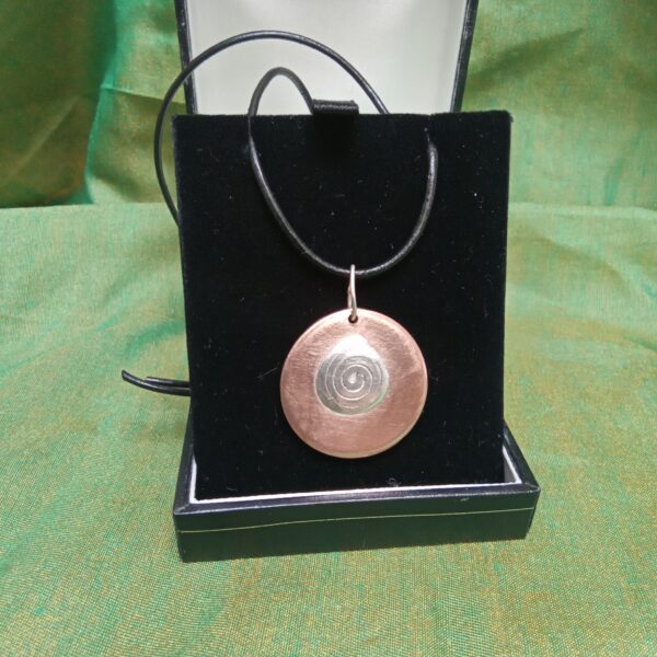 Handcrafted copper pendant with spiral of life silver inlay using recycled materials